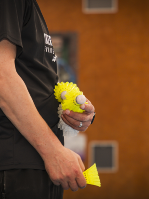 Homme tenant des volants de badminton dans la main