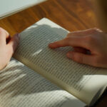 Des doigts parcourent les lignes d'un livre